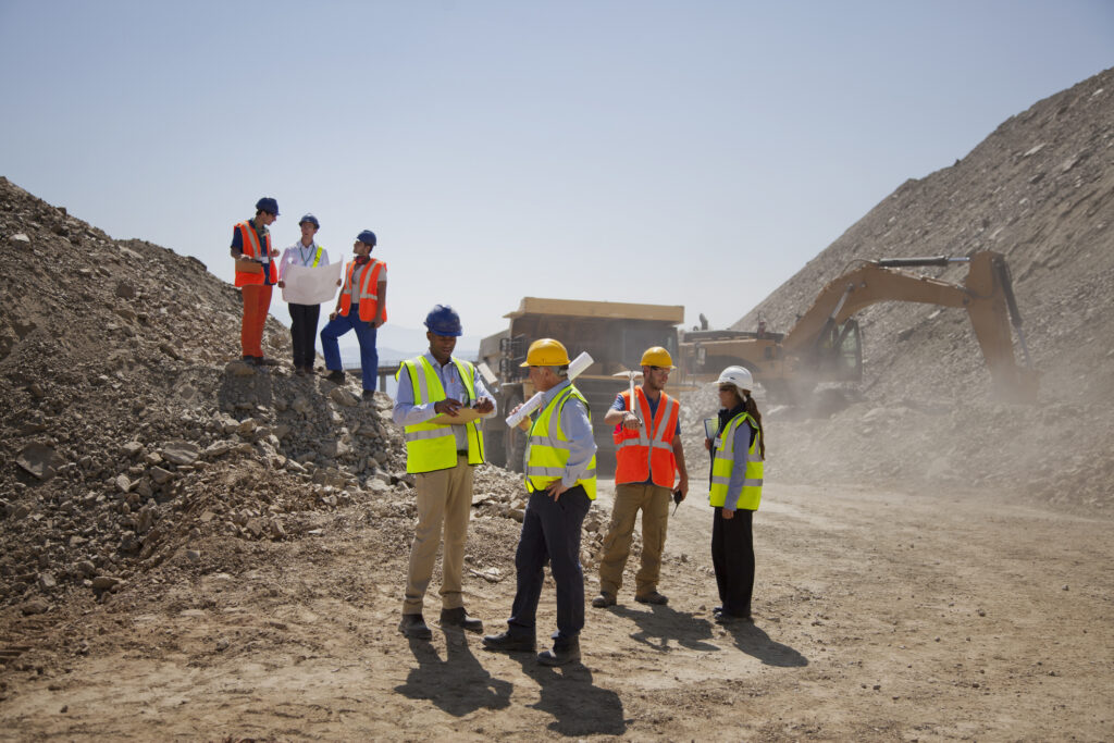 Business people and workers talking in quarry