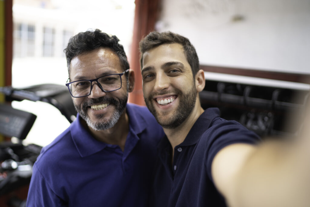 Mechanic partners taking a selfie in auto repair shop