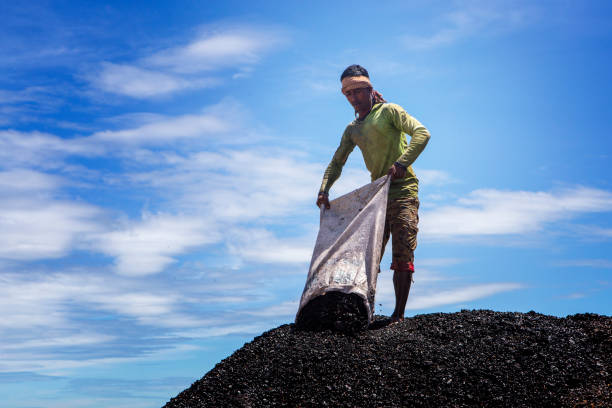 a worker is pouring coal in repository